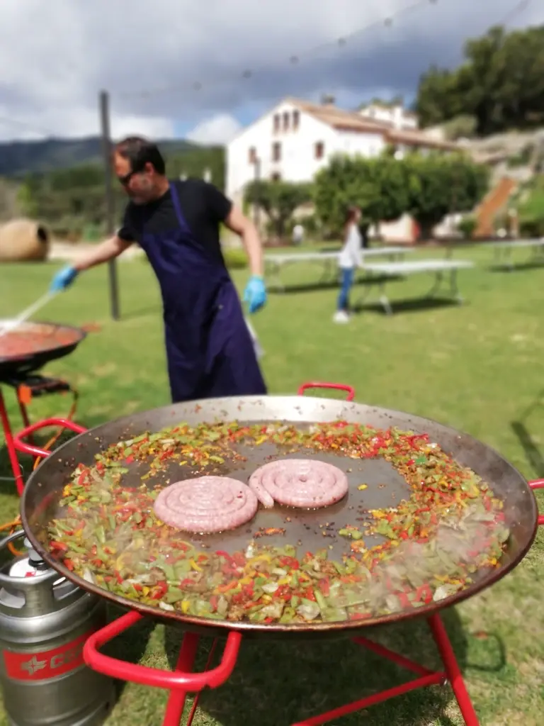 Els nuvis servint-se paella mixta en un banquet de boda informal