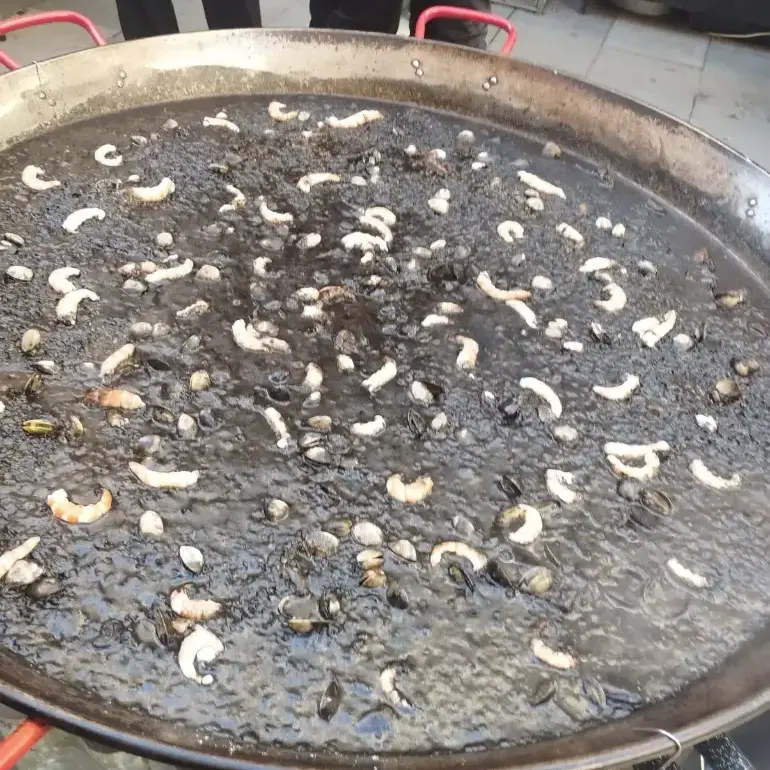 Paella d’arròs negre amb sípia i allioli.