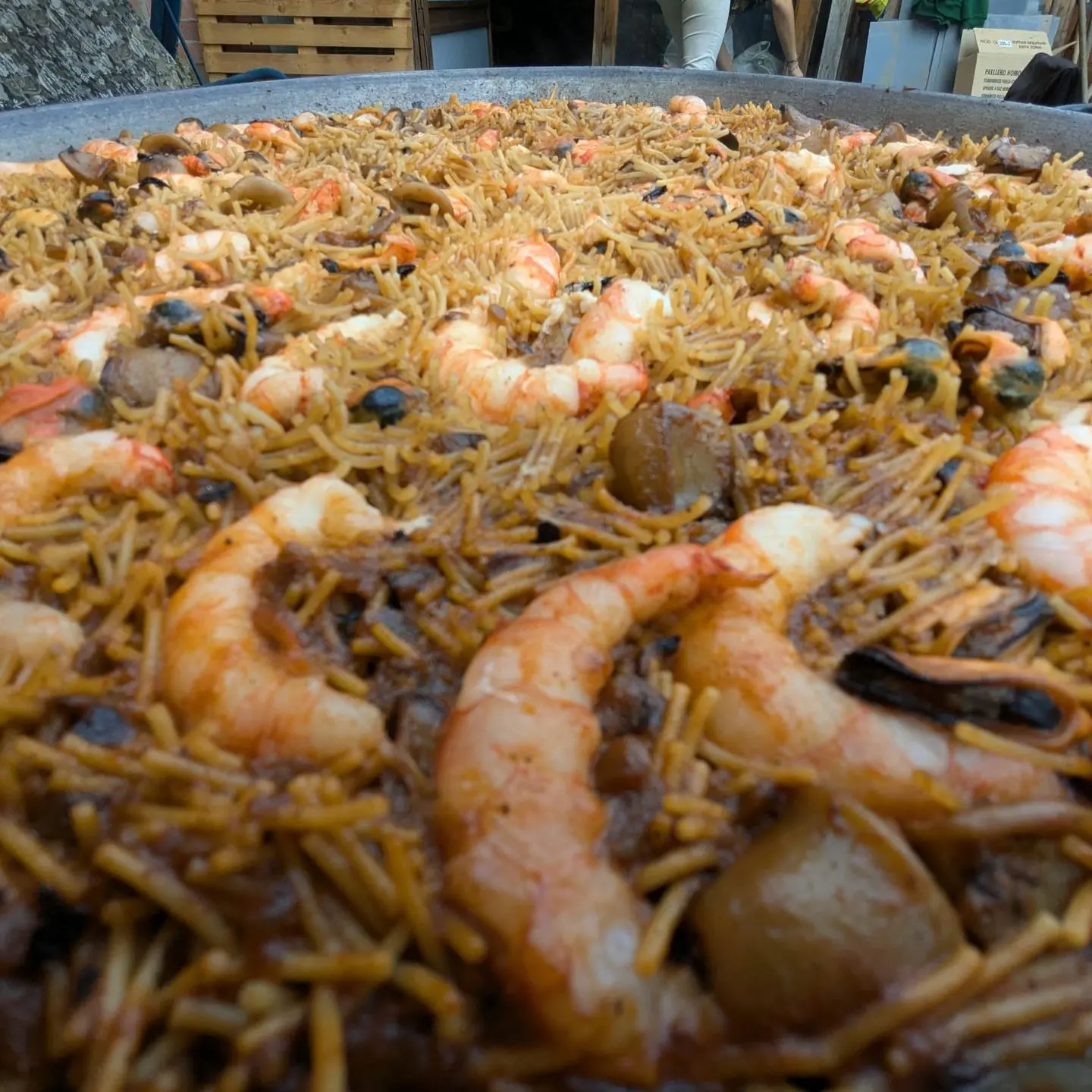 Fideuada marinera amb allioli llesta per servir en festa privada