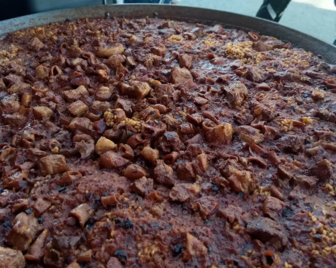 Paella mixta de carn i marisc cuinada per a grup gran
