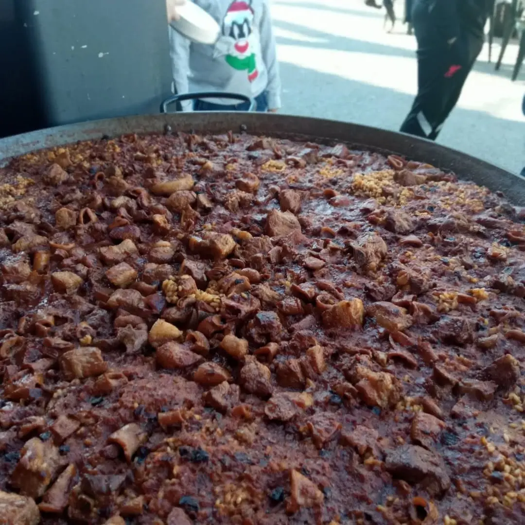Paella mixta de carn i marisc cuinada per a grup gran