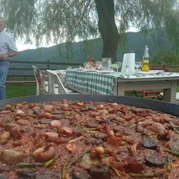 Plat de paella amb botifarra tradicional servida en festa popular
