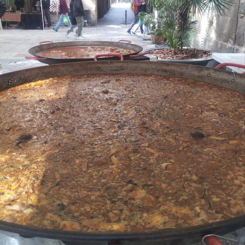 Evento con grupos grandes disfrutando de una paella popular servida in situ por Popaella