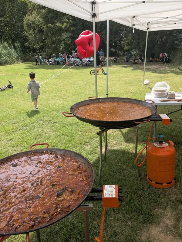 Dues paelles cuinant-se a l'aire lliure en una festa