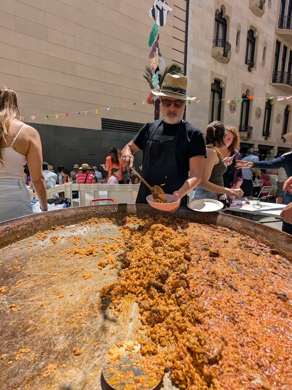 Cuiner servint paella en una festa al carrer