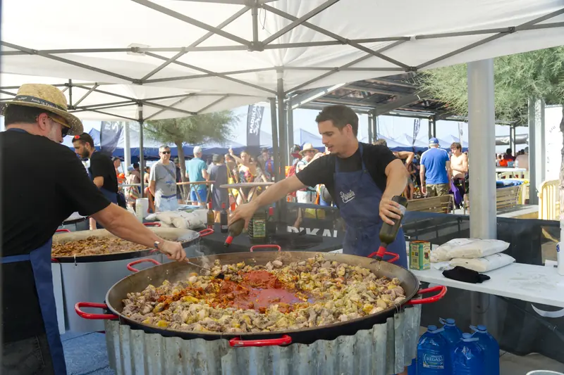 Dues paelles cuinant-se amb nedadors al voltant