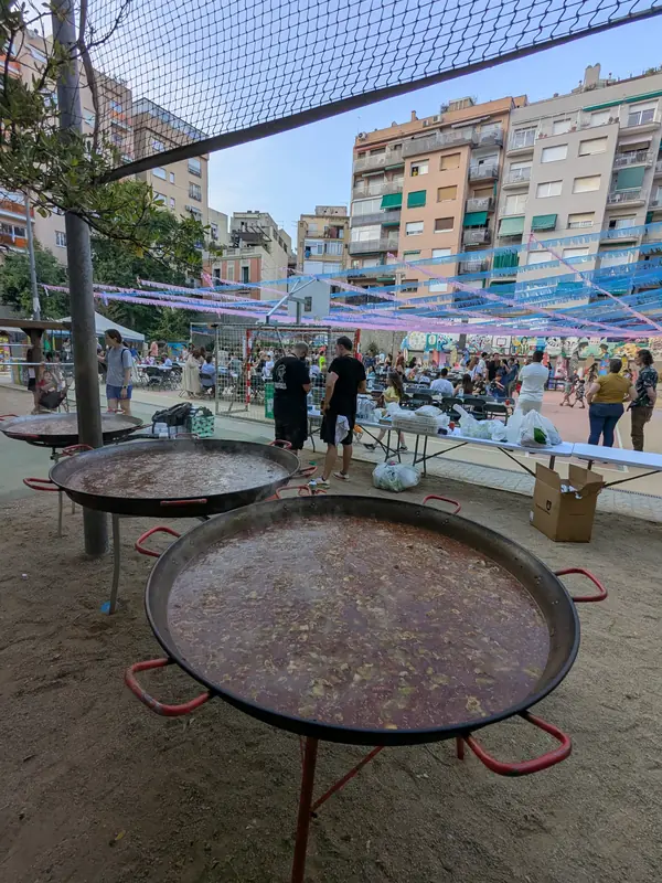 Paelles gegants a punt en una plaça de festa