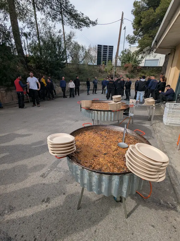Paella i plats a punt mentre es forma la cua