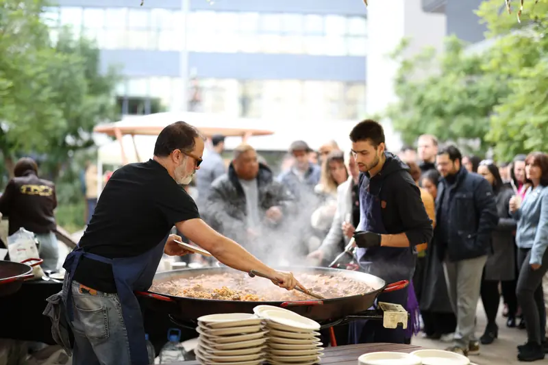 Dos cuiners servint una gentada en un esdeveniment d'empresa