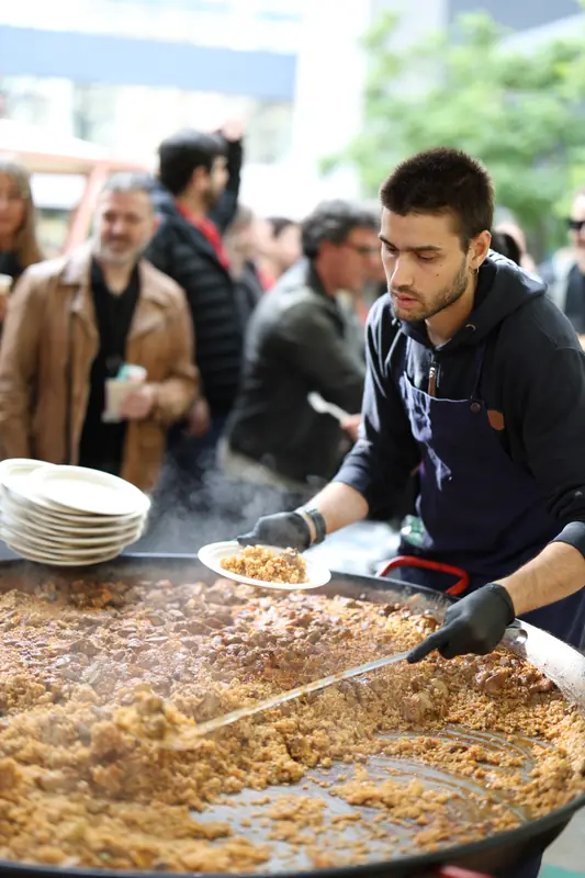 Servint de la paellera davant de la cua