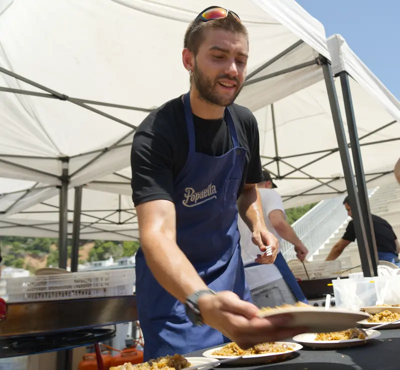 Servint plats de paella sota la carpa