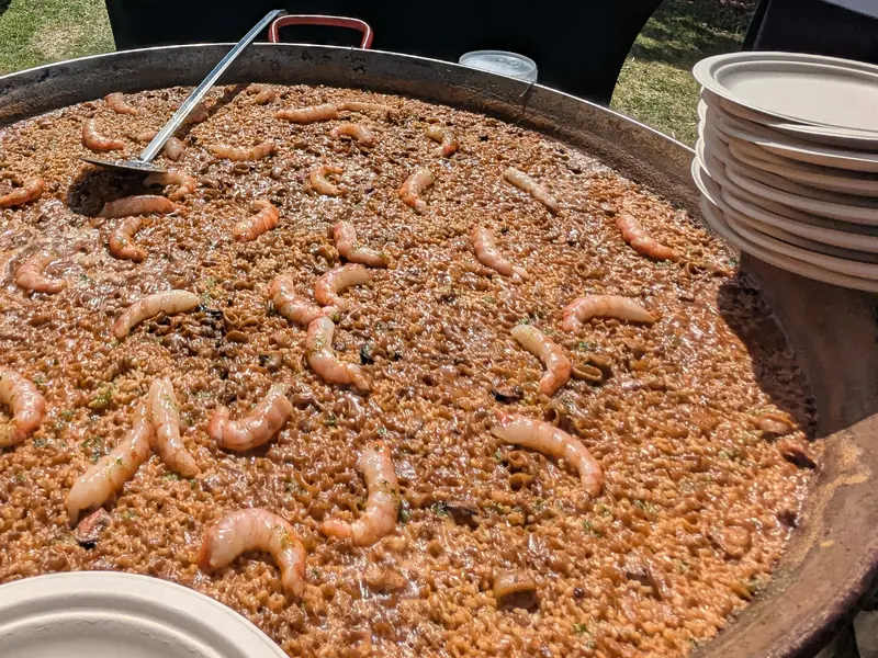 Paella de gambas con los platos listos para servir en una boda