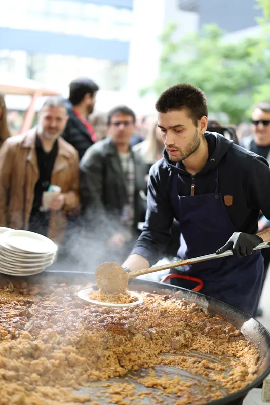 Cua de convidats esperant la paella